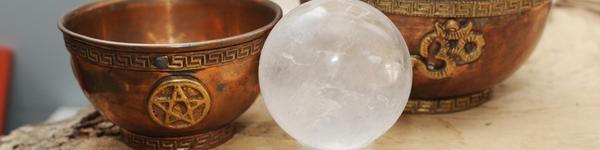copper wiccan offering bowls behind a crystal ball