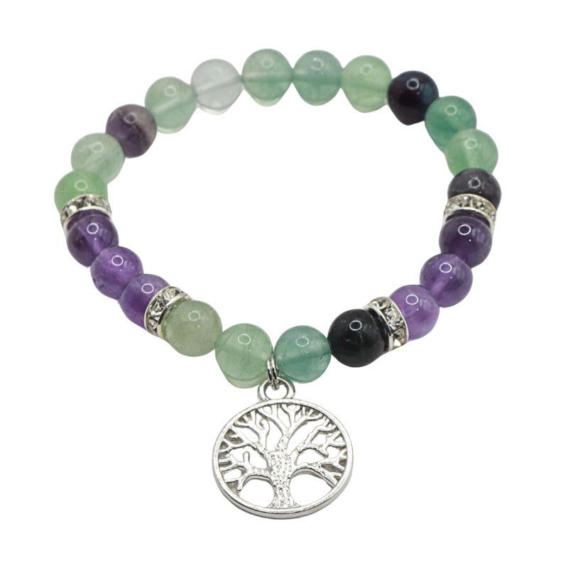 Beaded bracelet with tree of life charm on a white background