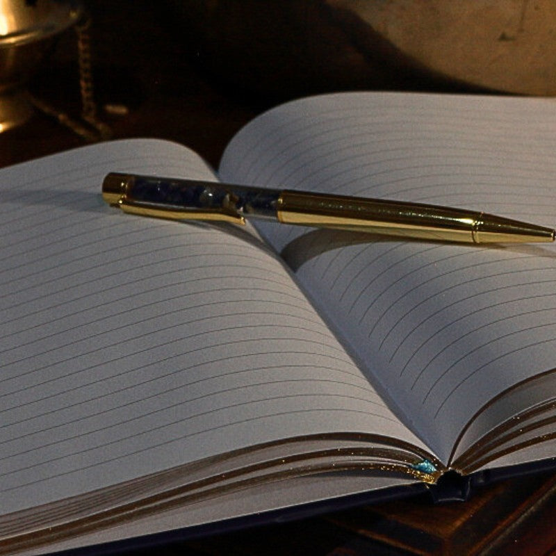 Open notebook with a gold pen on a wooden surface