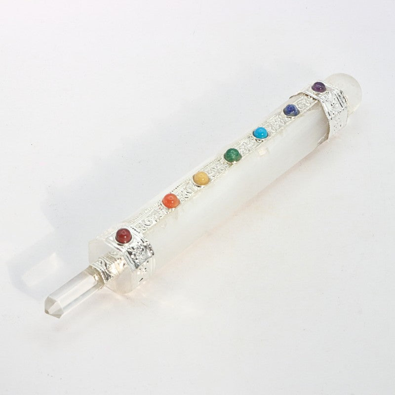 selenite crystal wand with chakra coloured stones on a white background