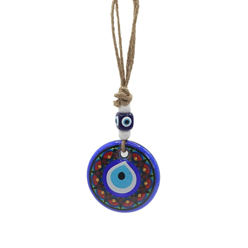 wall hanging with a blue evil eye pendant on a white background