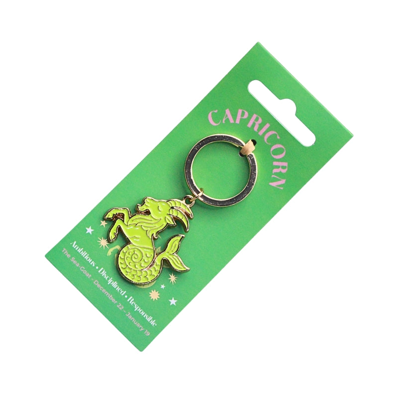 A green zodiac-themed keychain card featuring a Capricorn charm in gold and green, attached to a black split ring.
