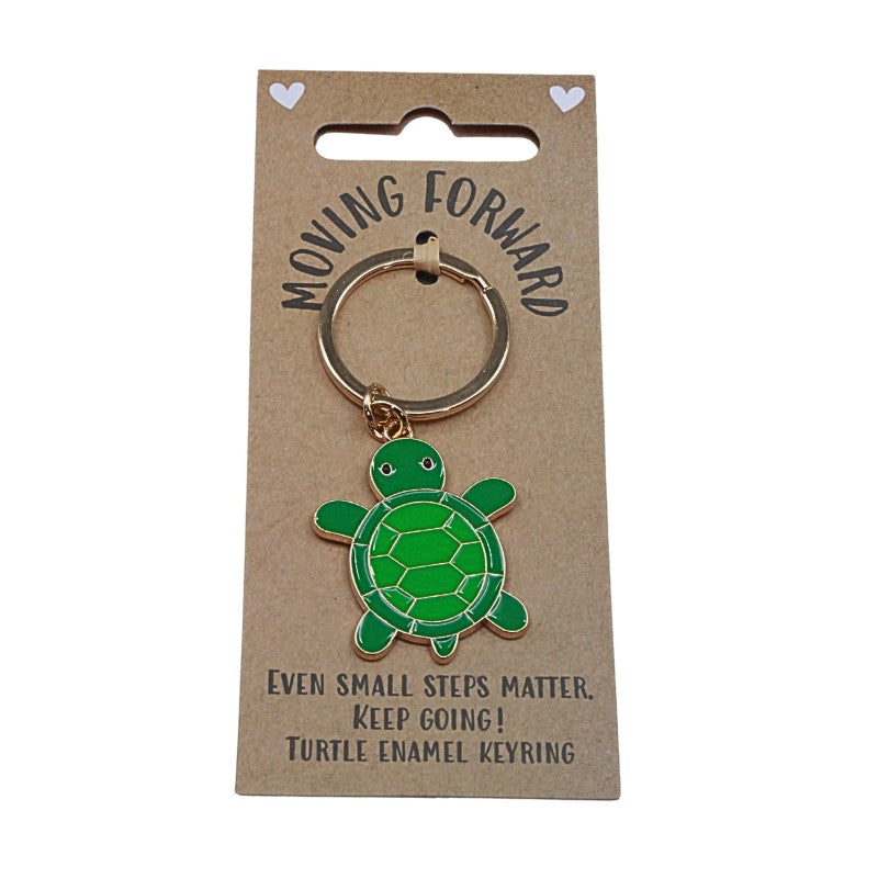 Green turtle enamel keyring on a 'Moving Forward' card with motivational text.