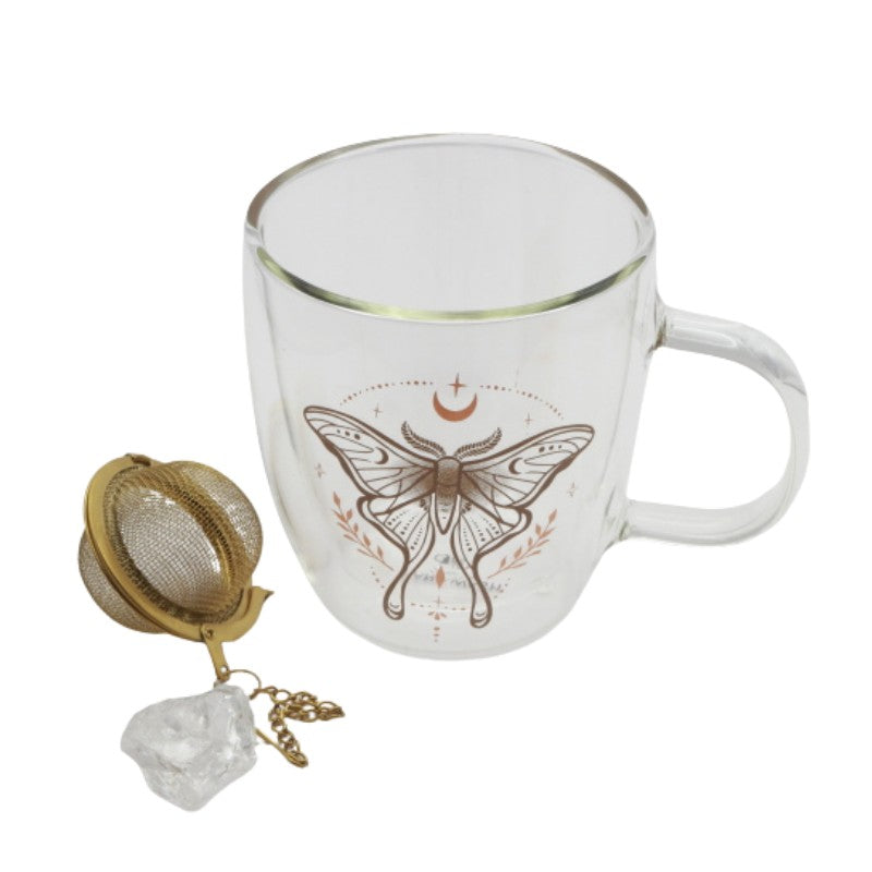 Glass mug with butterfly design, gold tea infuser, and crystal on a white background