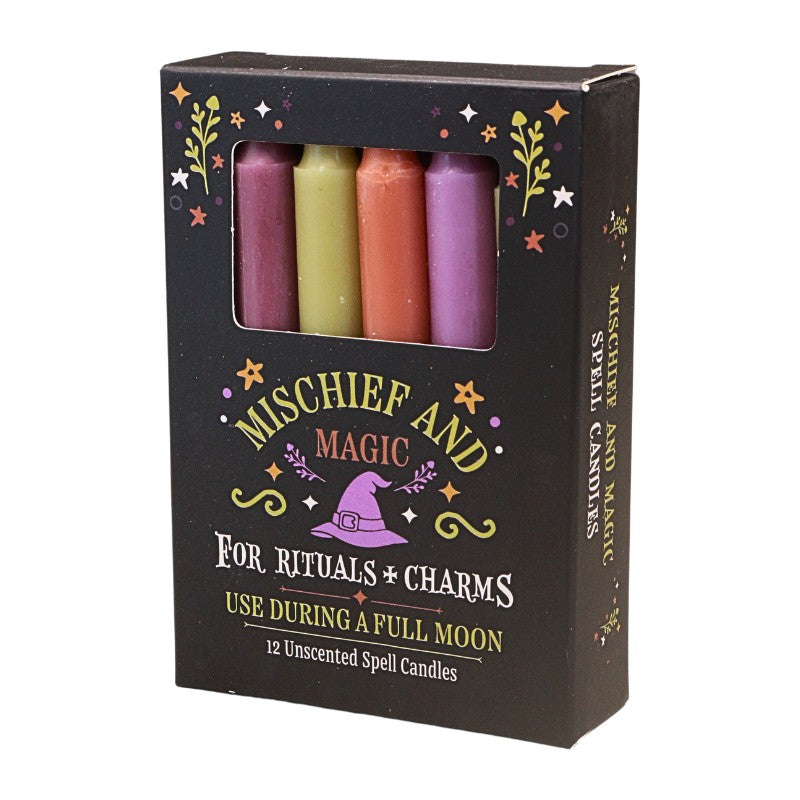 A box of 'Mischief and Magic' unscented spell candles, featuring four colorful wax candles visible through a clear window on a black packaging box with green and white text.