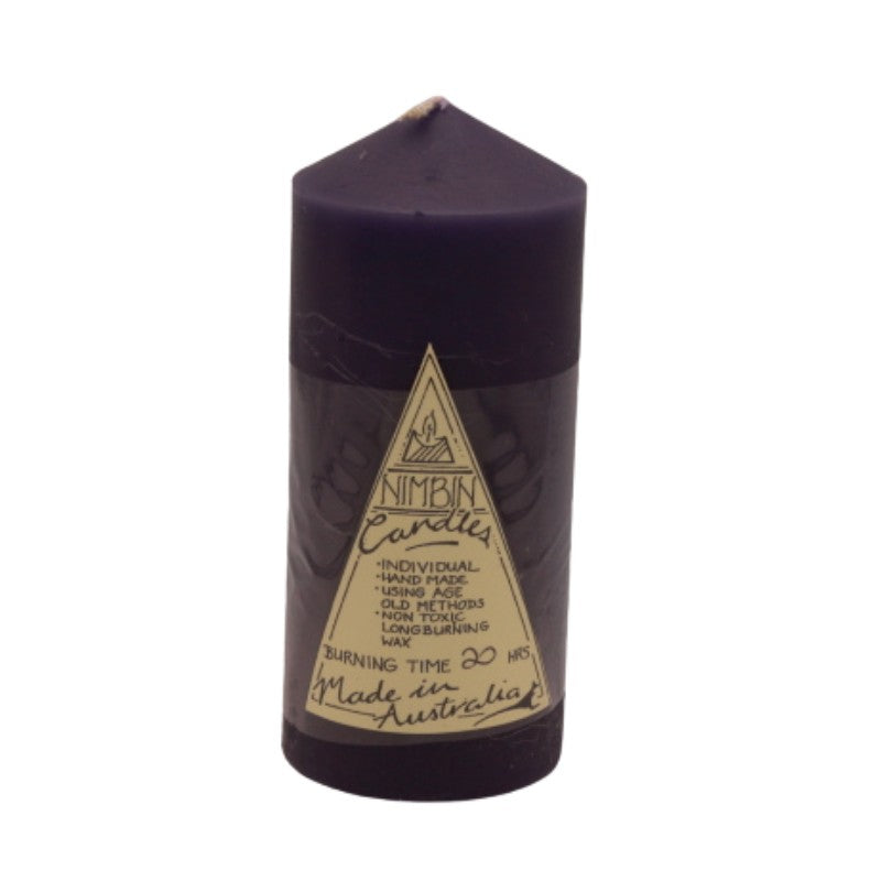 a purple pillar candle with a triangle label on the front
