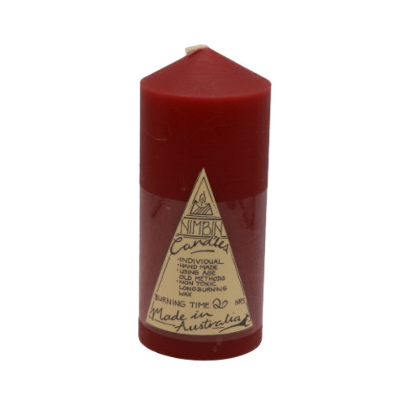a red pillar candle with a label on the front.