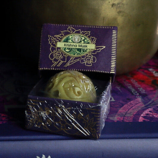 Krishna Musk Song Of India Natural Solid Perfume in front of singing bowl
