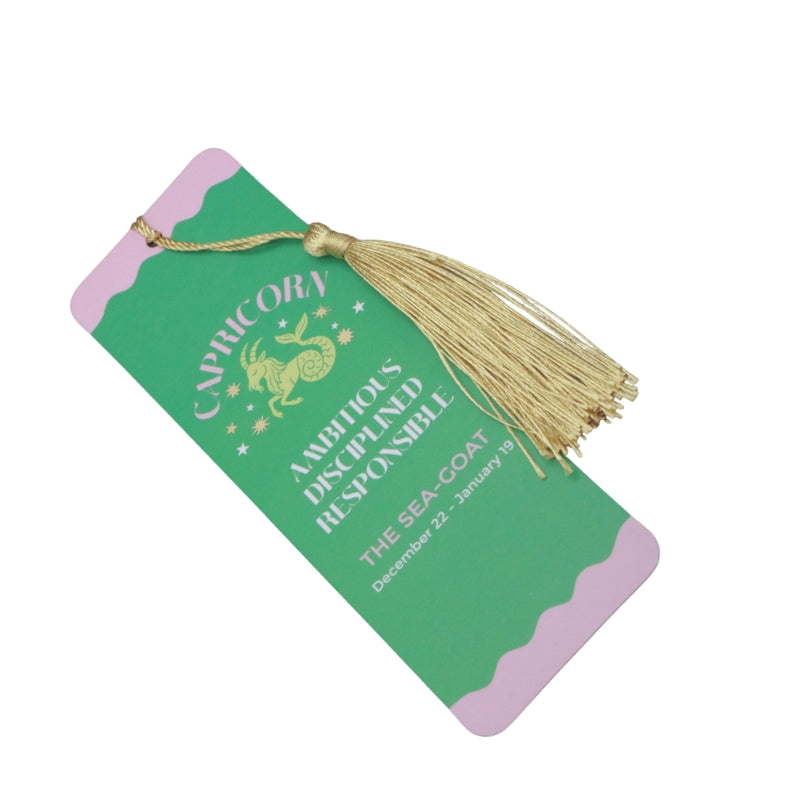 green and purple bookmark with gold tassel and white and purple writing, on a white background