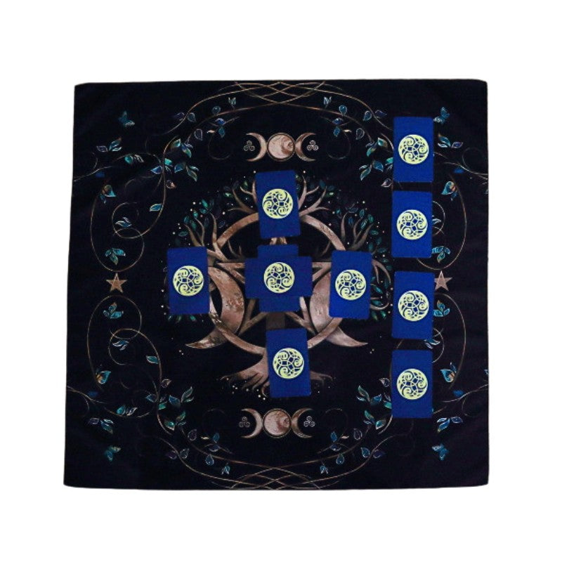 celtic cross spread laid out on a black tarot cloth with a triple moon pentacle design and tree
