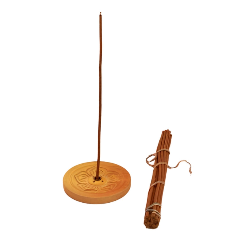 Round wooden carved incense holder- light wood with a tibetan incense stick in the centre, next to a bundle of tibetan incense sticks