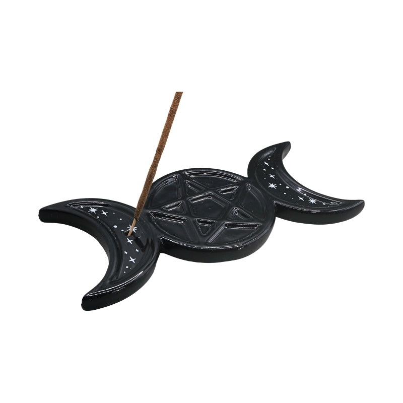 A black ceramic triple moon and pentagram incense holder with a brown incense stick, shown on a plain white background.
