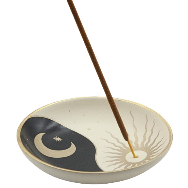 Incense burner with yin yang design and incense stick on a white background