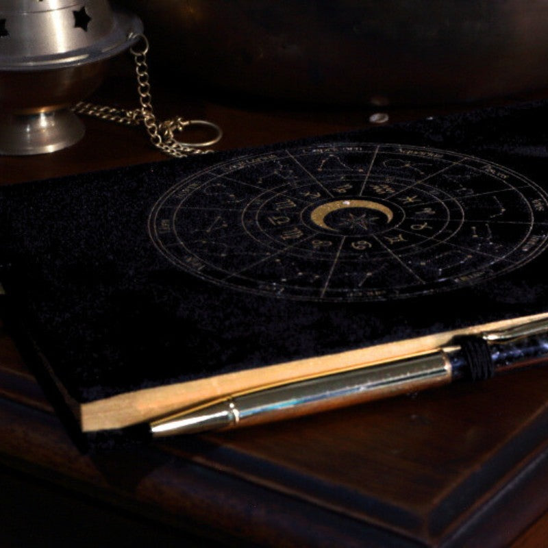 Black book with astrological symbols on a dark surface
