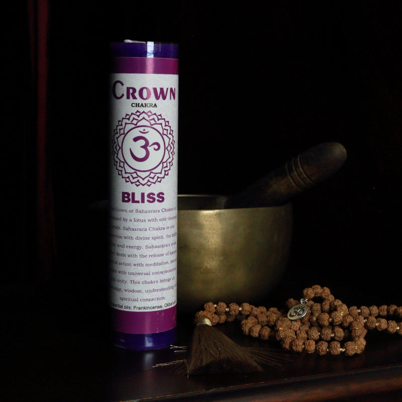 Purple Crown chakra pillar candle in front of a singing bowl with mala beads