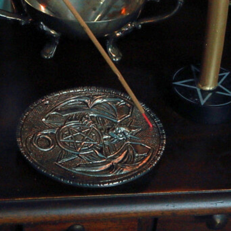 incense stick sitting in an aluminium incense holder