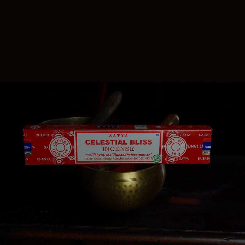 satya incense sticks sitting on a brass singing bowl