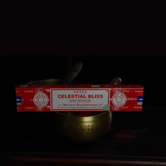 satya incense sticks sitting on a brass singing bowl