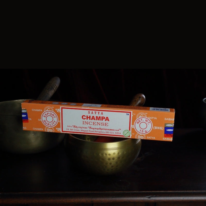 satya incense sticks sitting on a brass singing bowl