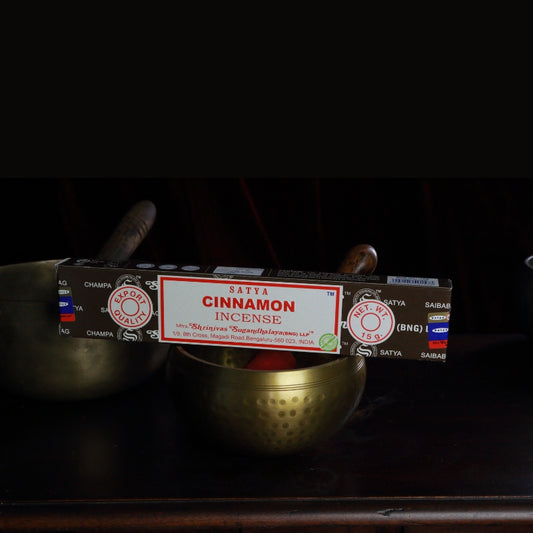 satya incense sticks sitting on a brass singing bowl