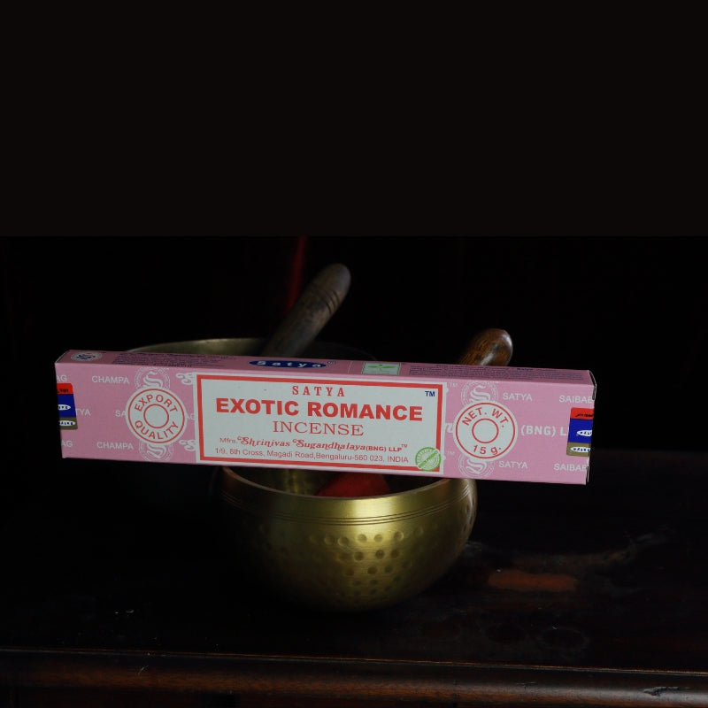 satya incense sticks sitting on a brass singing bowl