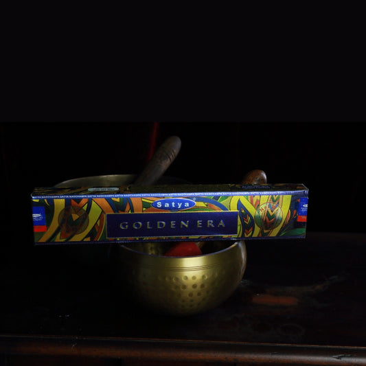 satya incense sticks sitting on a brass singing bowl