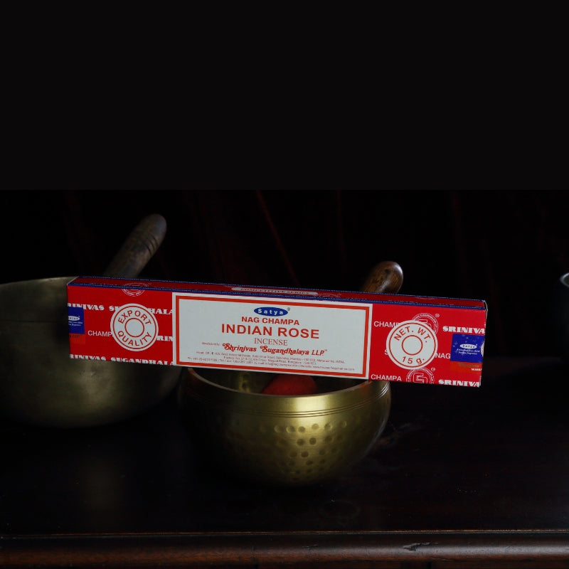 satya incense sticks sitting on a brass singing bowl