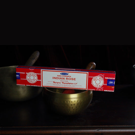 satya incense sticks sitting on a brass singing bowl