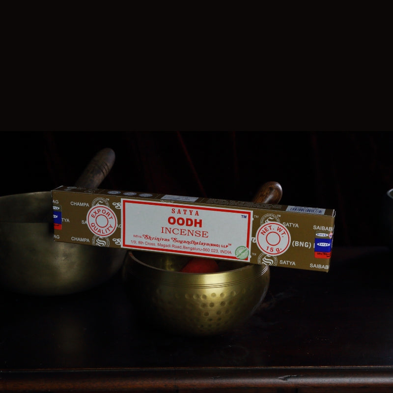 satya incense sticks sitting on a brass singing bowl