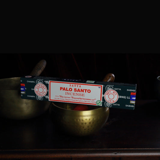 satya incense sticks sitting on a brass singing bowl