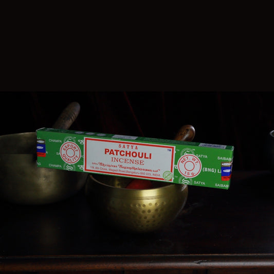 satya incense sticks sitting on a brass singing bowl