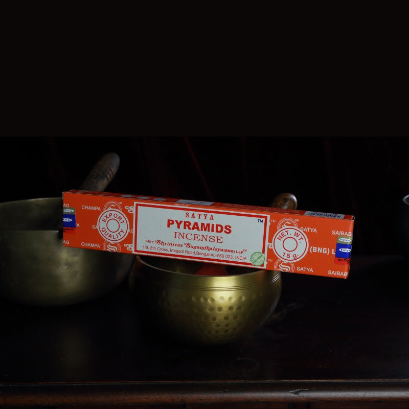 satya incense sticks sitting on a brass singing bowl