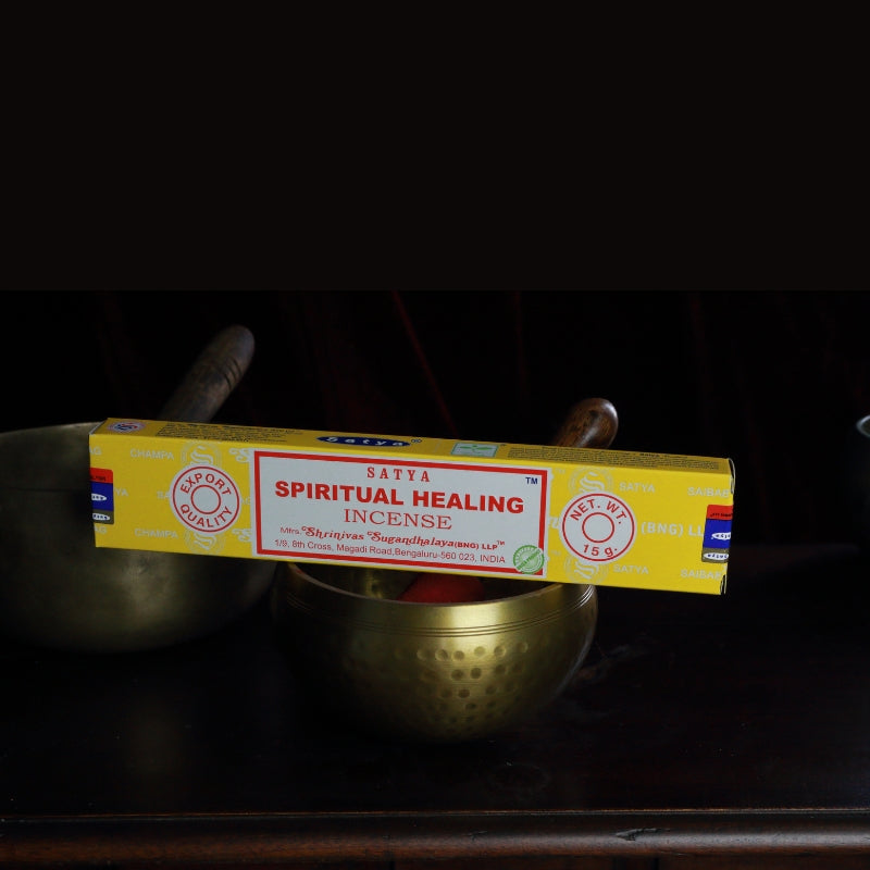 satya incense sticks sitting on a brass singing bowl