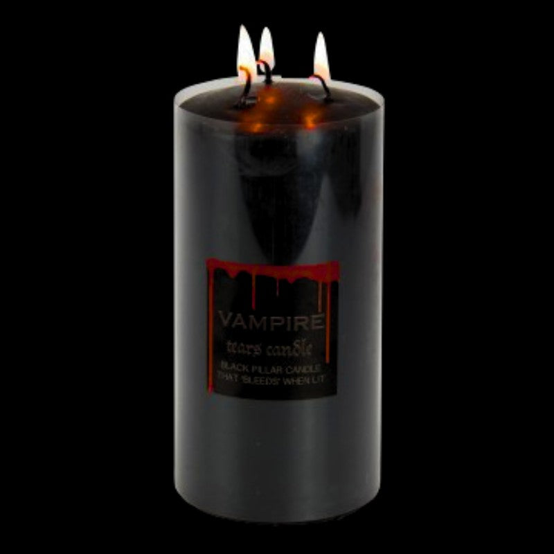 lit black pillar candle that bleeds red wax when lit