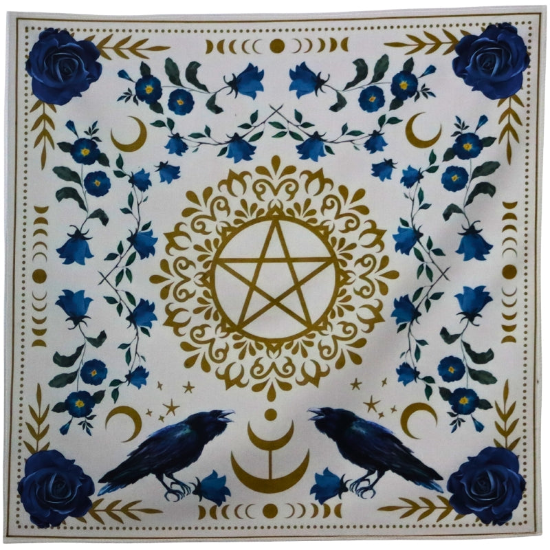 Tarot cloth. White with blue flowers surrounding a gold pentacle (5 pointed star surrounded by a circle). 2 ravens at the base of the pentacle.