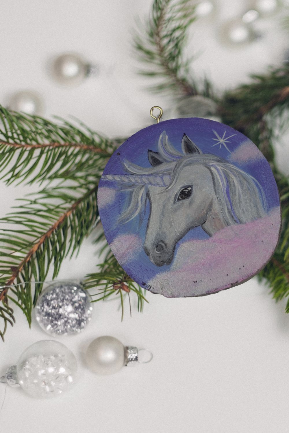 handpainted unicorn wood round ornament with baubles and Christmas tree branch