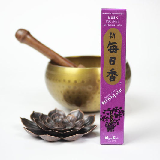 rectangle box of japanese morning star "Musk" incense sticks next to a lotus incense holder and brass singing bowl