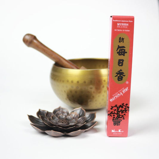 rectangle box of japanese morning star "Myrrh" incense sticks next to a lotus incense holder and brass singing bowl