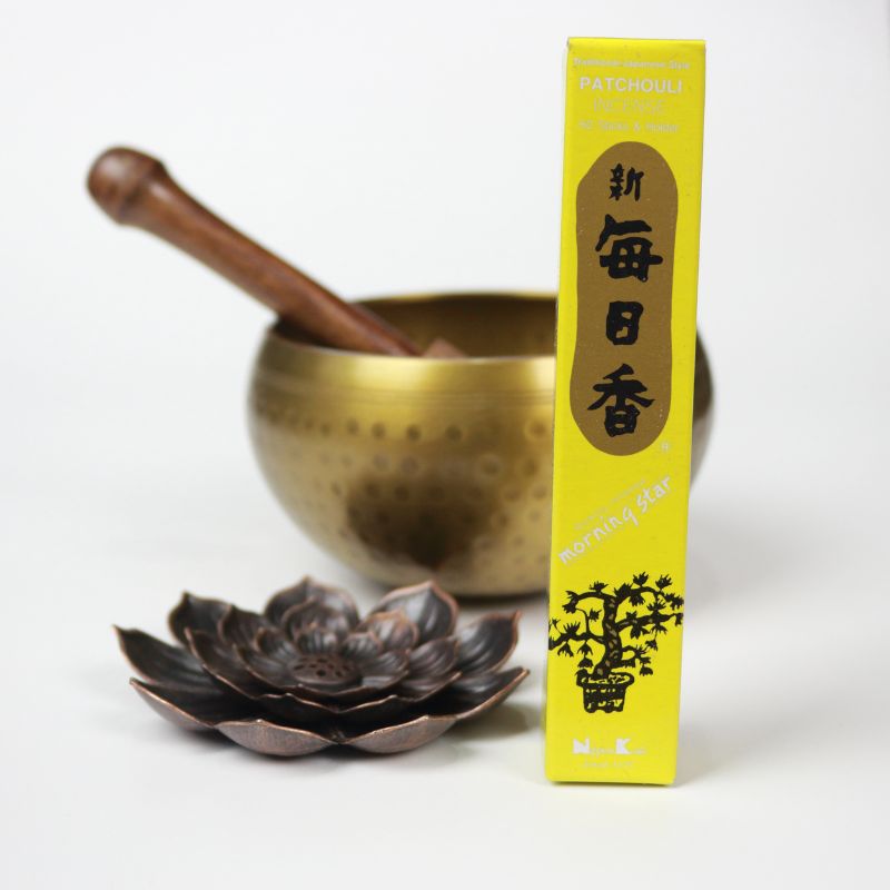 rectangle box of japanese morning star "Patchouli" incense sticks next to a lotus incense holder and brass singing bowl