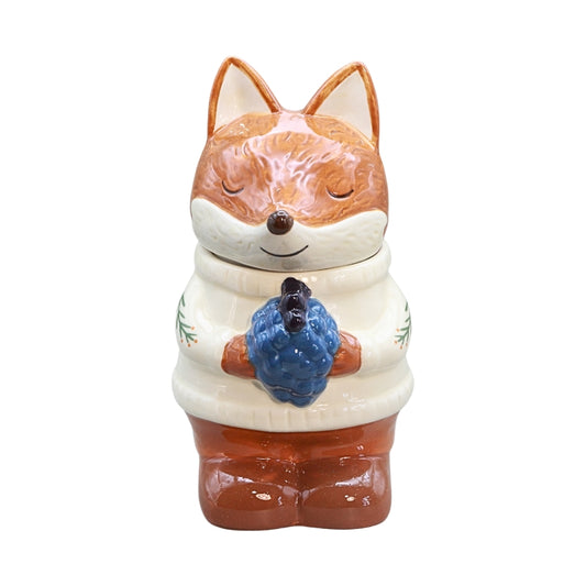 ceramic fox wearing a white jumper and holding blue berries, on a white background
