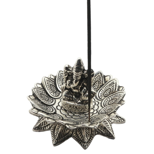 stick of incense in an  aluminium incense burner of a lotus with ganesh in the centre
