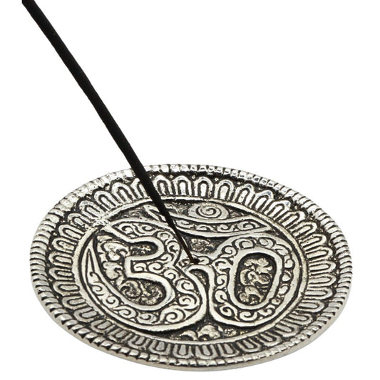 stick of incense in an aluminium incense holder with the om symbol