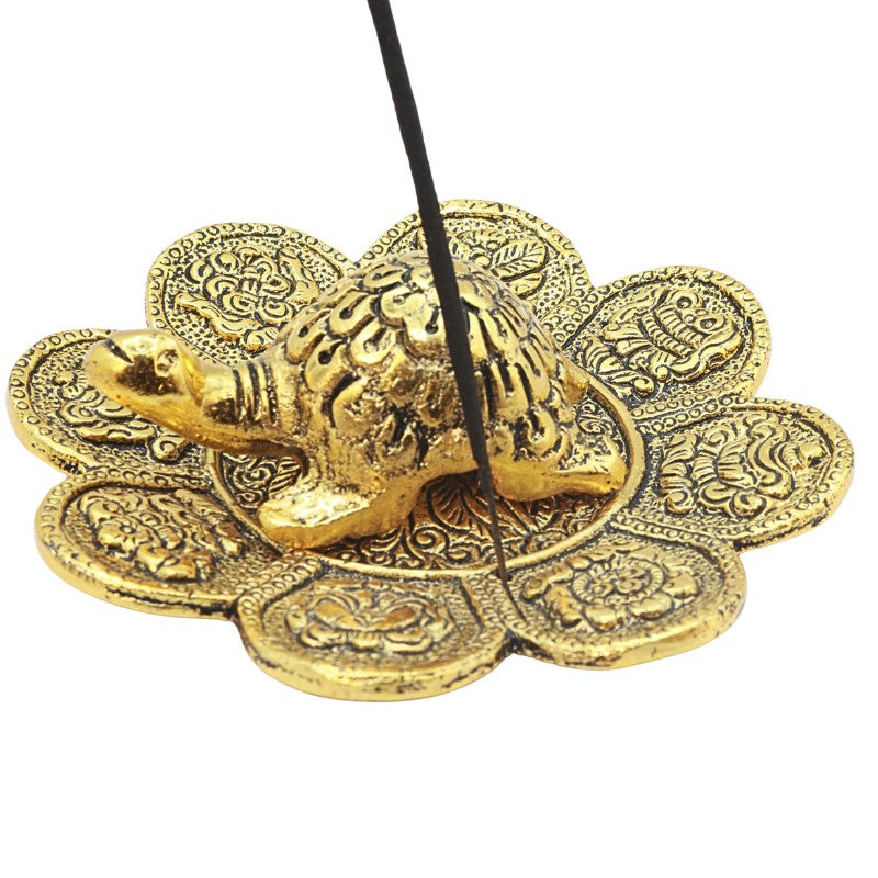 stick of incense in an aluminium incense holder with turtle