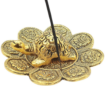 stick of incense in an aluminium incense holder with turtle