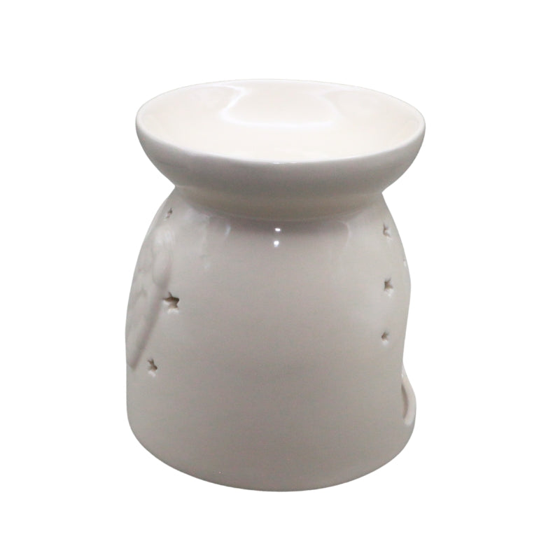 A white ceramic oil burner with a flared top and small star-shaped cutouts on the side, shown against a plain white background.
