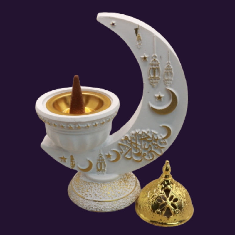 white and gold incense burner in the shape of a crescent moon