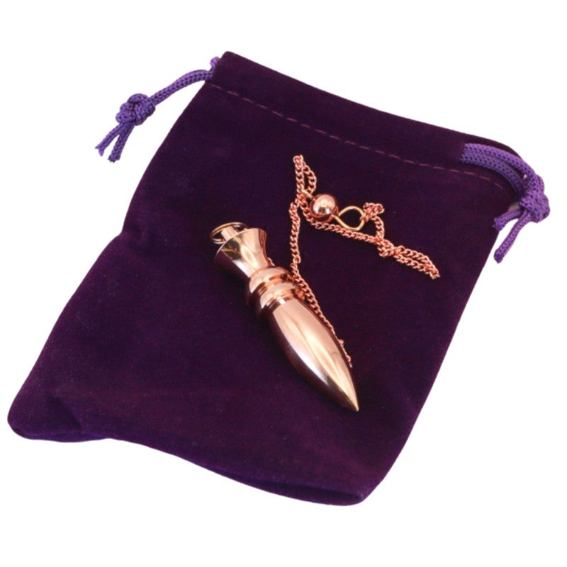 Brass pendulum on purple velvet pouch
