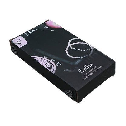Black coffin-shaped product packaging with white text and designs on a white background