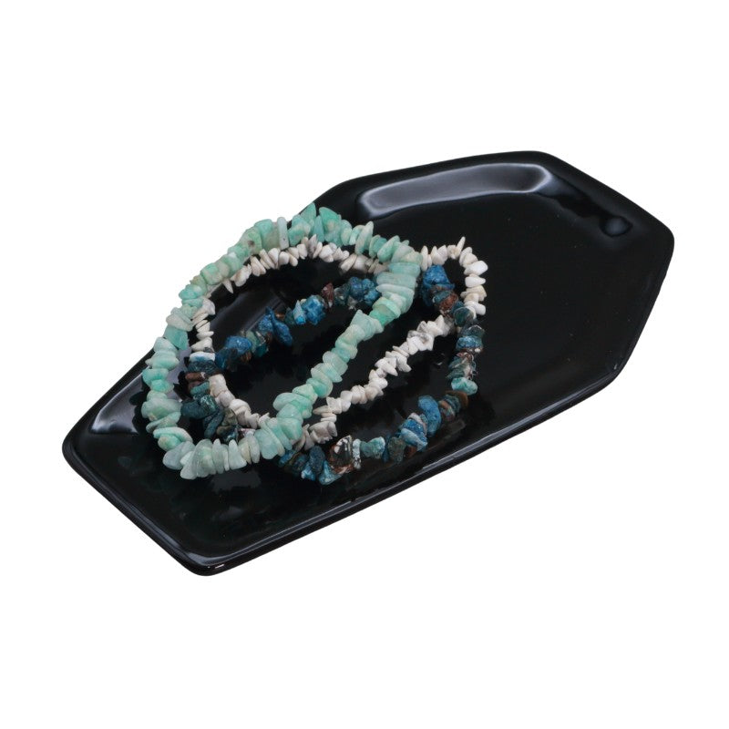 Set of beaded bracelets on a black tray with a white background