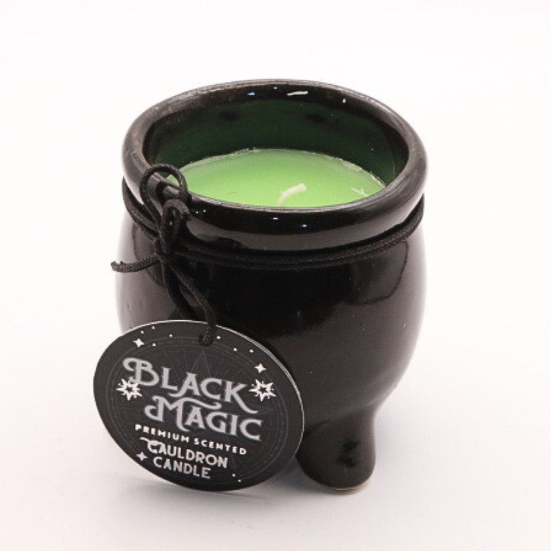 a coloured candle housed in a black ceramic cauldron